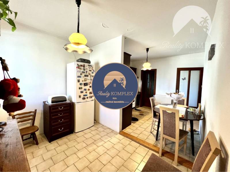 Ponúka na PREDAJ zrekonštruovaný 5 izbový podpi - Jedáleň v rodinnom dome s chladničkou, svetlami a stolom pre štyri osoby.