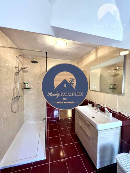 Ponúka na PREDAJ zrekonštruovaný 5 izbový podpi - Kúpeľňa v rodinnom dome s dlažbou, sprchovým kútom a umývadlom.