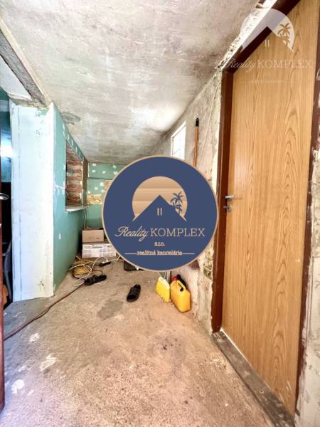 Ponúka na PREDAJ viničný domček s priestranným  - Úložná miestnosť v Chate s nástrojmi a drevenými dverami, ktorá potrebuje úpravu.