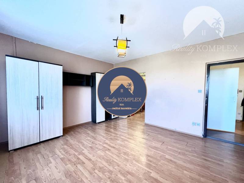 Ponúka na PREDAJ 1 izbový byt v Komárne - Šatníková skriňa a podlaha s dreveným dekorom v 1-izbovom byte.