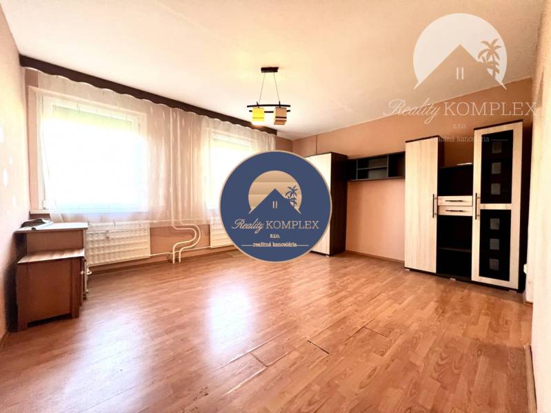 Ponúka na PREDAJ 1 izbový byt v Komárne - Svetlá izba v 1-izbovom byte s policovou skriňou a podlahou s dreveným dekorom.