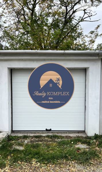 Vám ponúka na PRENÁJOM zrekonštruovanú garáž v  - Garáže na Nevädzovej ulici v Dunajskej Strede s bielymi dverami a stromami v pozadí.