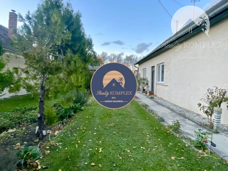 Investičný pozemok s obývateľným domom vo Vrakúni - Rodinný dom vo Vrakúni s udržiavanou záhradou, popri dome vedie chodník.