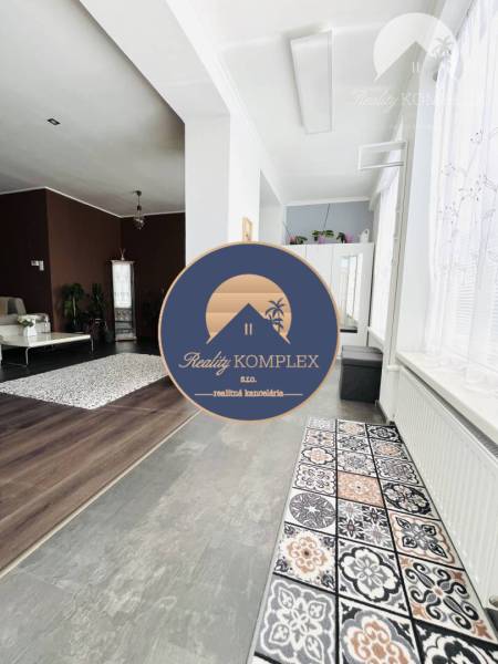 Vám ponuka na predaj útulný 3-izbový rodinný d - Interiér rodinného domu s podlahou s dreveným dekorom a vzorovaným kobercom.