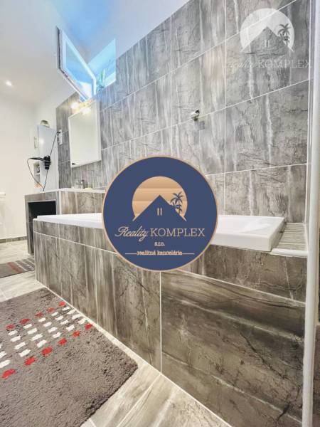 Vám ponuka na predaj útulný 3-izbový rodinný d - Kúpeľňa v rodinnom dome s vaňou a šedým obkladom.