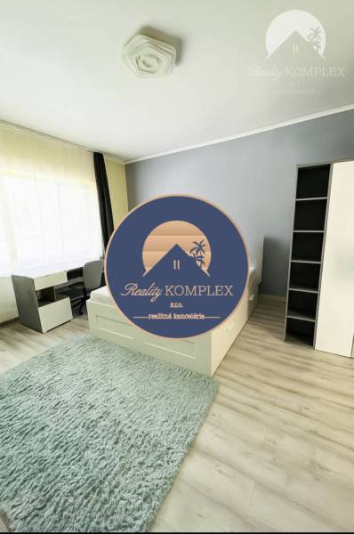 Vám ponuka na predaj útulný 3-izbový rodinný d - Svetlá izba v rodinnom dome s posteľou, písacím stolom a podlahou s dreveným dekorom.