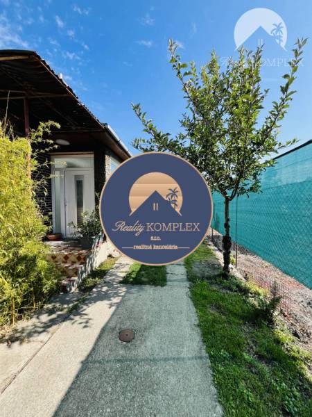 Vám ponuka na predaj útulný 3-izbový rodinný d - Záber na vstup do rodinného domu vo Veľkom Mederi, s chodníkom a zeleňou.