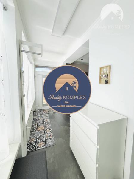 Vám ponuka na predaj útulný 3-izbový rodinný d - Interiér rodinného domu s bielou komodou a vzorovaným kobercom.