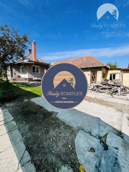 Vám ponuka na predaj útulný 3-izbový rodinný d - Rodinný dom vo Veľkom Mederi obklopený trávnikom s vedľajšou budovou a stromom.