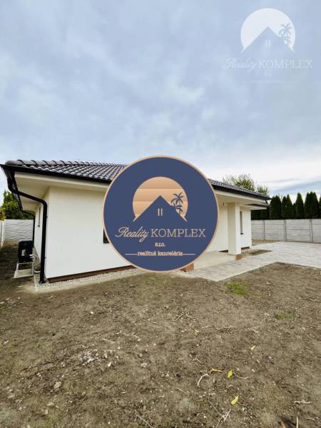 Vám ponúka na predaj moderný 4-izbový bungalov - Rodinný dom v Topoľníkoch so šikmou strechou a dláždeným chodníkom na dvore.