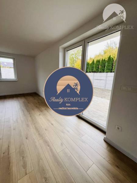 Vám ponúka na predaj moderný 4-izbový bungalov - Interiér rodinného domu s oknami a podlahou s dreveným dekorom.