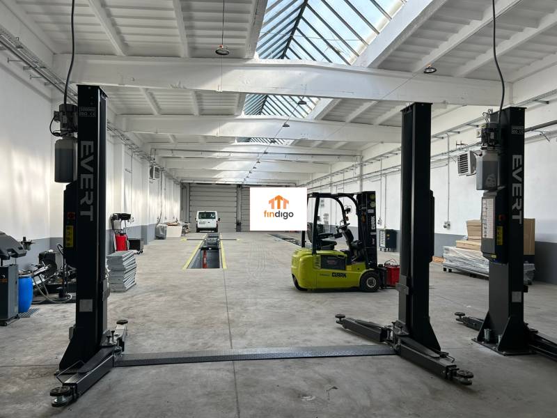 Autoservis s výbavou pre vozidlá v uzavretom priemyselnom areáli - HC - Interiér budovy s vysokozdvižným vozíkom a automechanickou technikou.