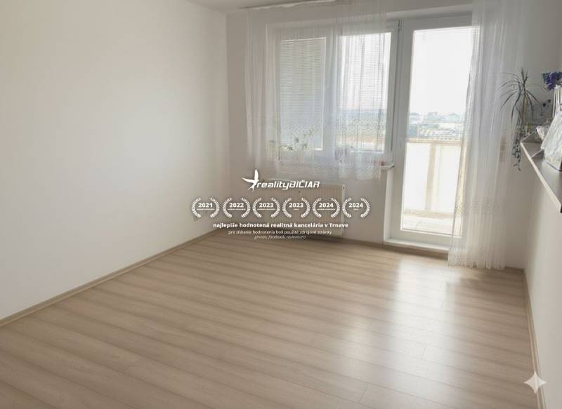 Exkluzívne v našej RK 3 izbový byt po rekonštrukcii s dvomi loggiami - Izba v 3-izbovom byte s podlahou s dreveným dekorom a balkónovými dverami.