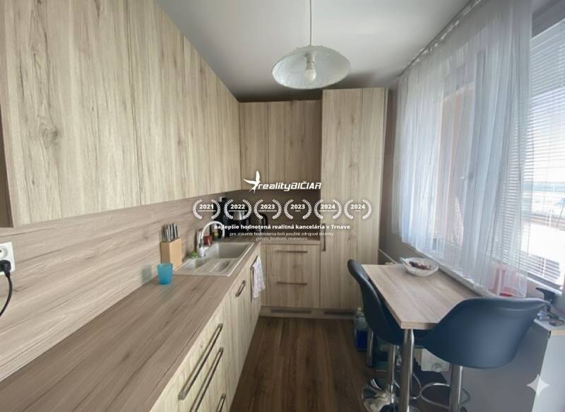 Exkluzívne v našej RK 3 izbový byt po rekonštrukcii s dvomi loggiami - Kuchyňa v 3-izbovom byte s podlahou s dreveným dekorom a svetlým nábytkom.