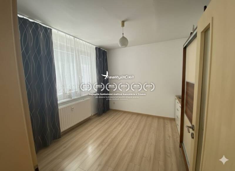 Exkluzívne v našej RK 3 izbový byt po rekonštrukcii s dvomi loggiami - Priestranná miestnosť v 3-izbovom byte s podlahou s dreveným dekorom a veľkým oknom.