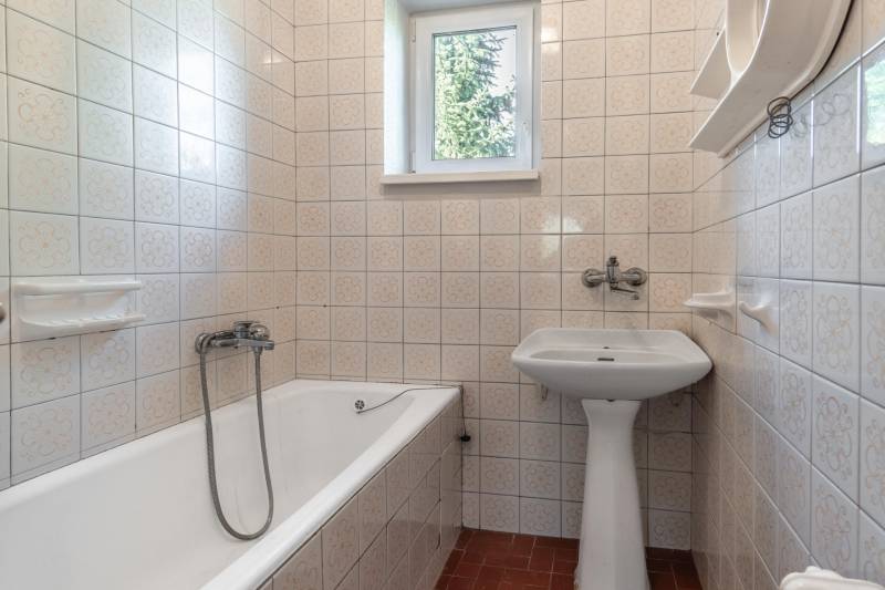 I Na predaj dvojposchodový 5i rodinný dom pri Žiline - Kúpeľňa v Rodinnom dome s vaňou, umývadlom a obkladmi v kvetovanom vzore.