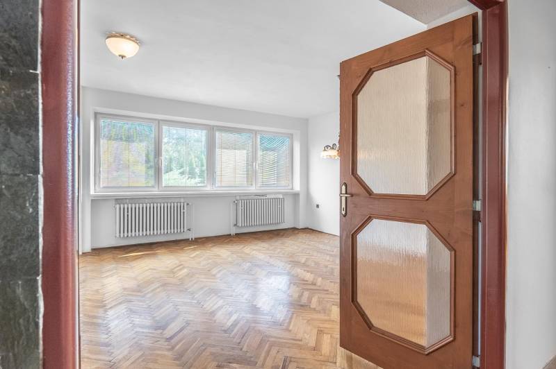 I Na predaj dvojposchodový 5i rodinný dom pri Žiline - Interiér rodinného domu s podlahou s dreveným dekorom a veľkými oknami.