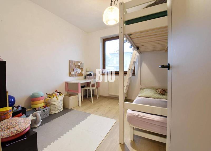 Veľkometrážny 3 izbový byt s garážou - Detská izba s poschodovou posteľou, písacím stolom a podlahou s dreveným dekorom v 3-izbovom byte.