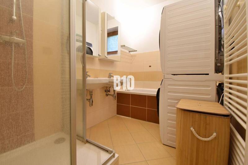 Veľkometrážny 3 izbový byt s garážou - Kúpeľňa v 3-izbovom byte s práčkou, sprchovým kútom a vaňou.