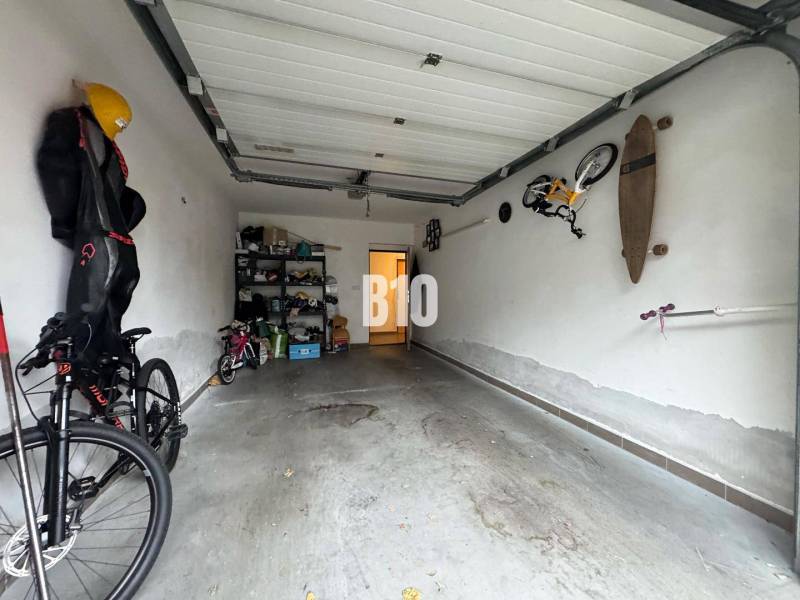 Veľkometrážny 3 izbový byt s garážou - Garáž v 3-izbovom byte s bicyklami a poličkami na uloženie.