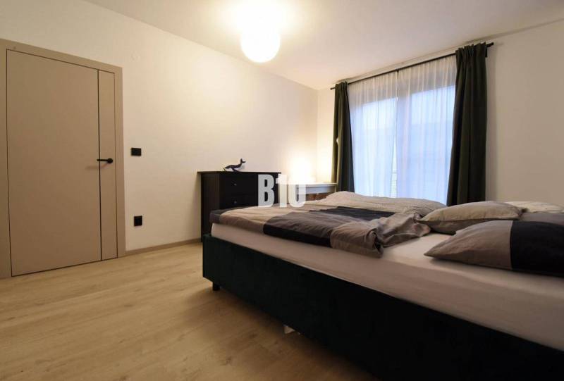 Veľkometrážny 3 izbový byt s garážou - Spálňa s dvojlôžkom a podlahou s dreveným dekorom v 3-izbovom byte.