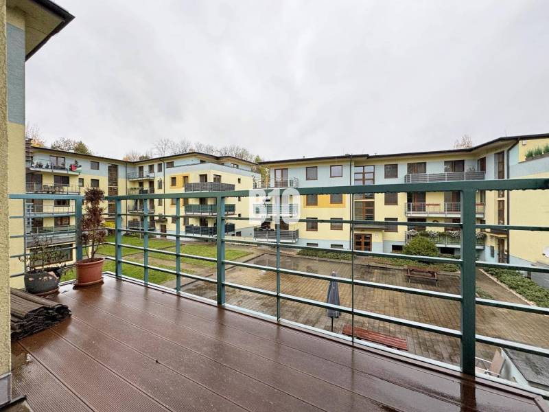 Veľkometrážny 3 izbový byt s garážou - Pohľad z 3-izbového bytu v Žiline na vnútorný dvor s terasou a zábradlím.