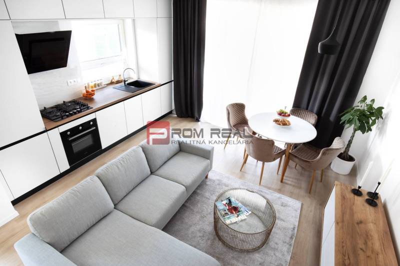 Na predaj 3 izbový dvojpodlažný byt Ivanka pri Dunaji - Kuchyňa s obývačkou v 3-izbovom byte, biely nábytok, podlaha s dreveným dekorom.