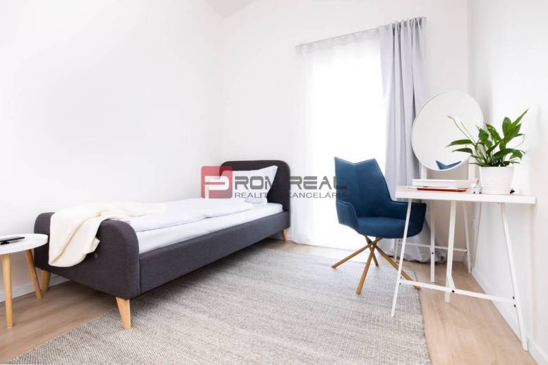 Na predaj 3 izbový dvojpodlažný byt Ivanka pri Dunaji - Spálňa v 3-izbovom byte s posteľou, okrúhlym stolom a písacím stolom s kreslom.