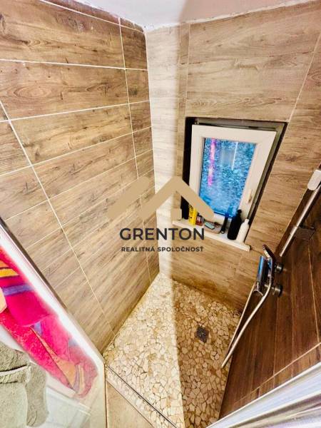 4 izbová celoročná chata v Kučišdorfskej doline na predaj - Sprchový kút s dekorom dreva v interiéri chaty, doplnený mozaikovou dlažbou a oknom.