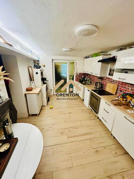 4 izbová celoročná chata v Kučišdorfskej doline na predaj - Kuchyňa v Chate s podlahou s dreveným dekorom a bielym nábytkom.