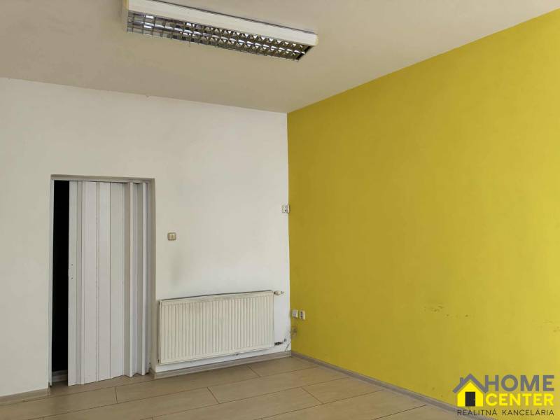 PRENÁJOM obchodný priestor/kancelária v priamom centre - KOMÁRNO - Interiér obchodných priestorov s podlahou s dreveným dekorom a žltou stenou.