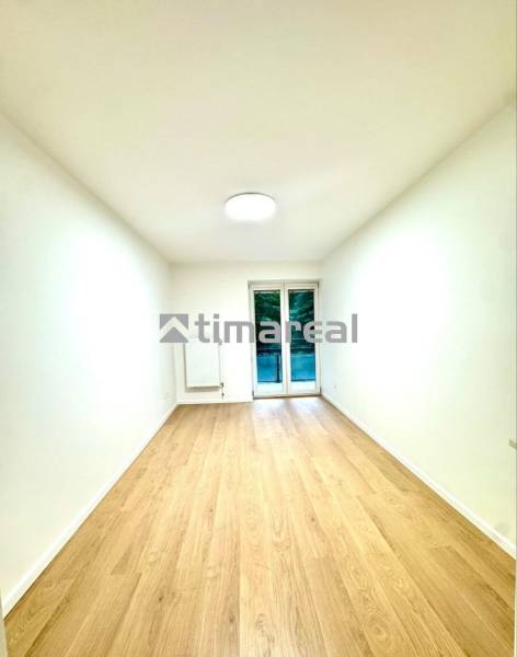 Krásny 4i byt v príjemnej lokalite BA - Biela izba v 4-izbovom byte s podlahou s dreveným dekorom a balkónovými dverami.