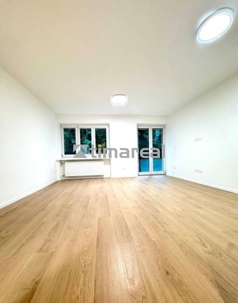 Krásny 4i byt v príjemnej lokalite BA - Interiér 4-izbového bytu s podlahou s dreveným dekorom, bielymi stenami a oknami.