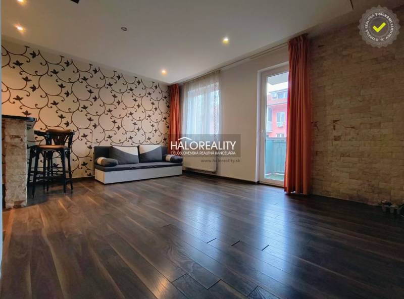 Prenájom, dvojizbový byt Dunajská Streda - Obývacia izba v 2-izbovom byte so vzorovanou tapetou a podlahou s dreveným dekorom.