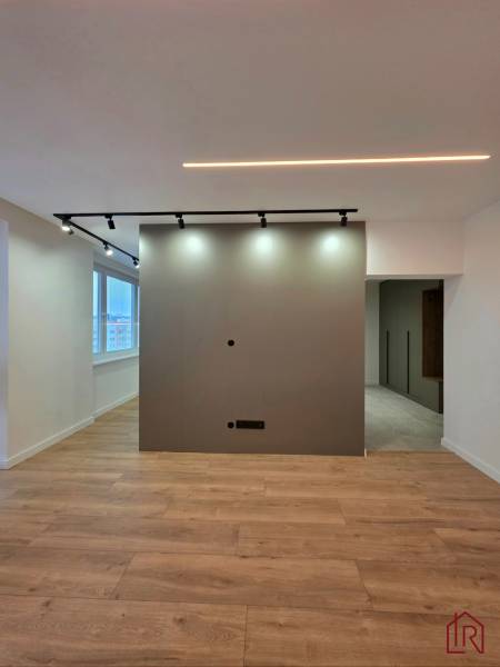 REZERVOVANÝ - Moderný 3-izbový byt po rekonštrukcii na Terase, Košice - 3-izbový byt s osvetlením, stenou a podlahou s dreveným dekorom.