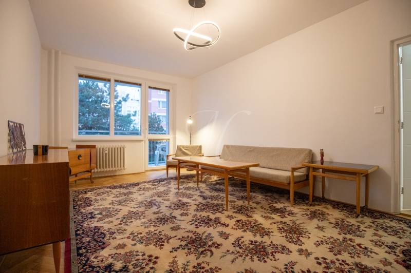 Slnečný 3-izbový byt, Kramáre - Obývačka v 3-izbovom byte so starožitným kobercom a dreveným nábytkom.