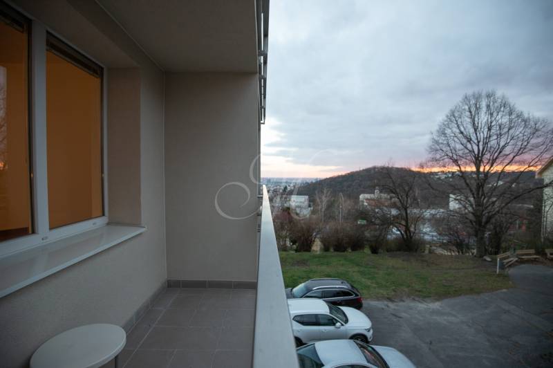 Slnečný 3-izbový byt, Kramáre - Balkón 3-izbového bytu s výhľadom na zeleň a zaparkované autá v Bratislave na Kramároch.