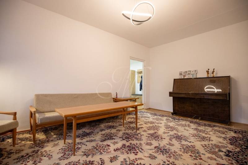 Slnečný 3-izbový byt, Kramáre - Obývačka v 3-izbovom byte s kobercovým dekorom a klavírom.