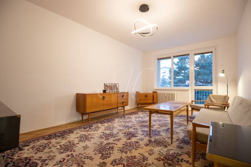 Slnečný 3-izbový byt, Kramáre - Obývacia izba s retro nábytkom, kobercom a lustrom v 3-izbovom byte.