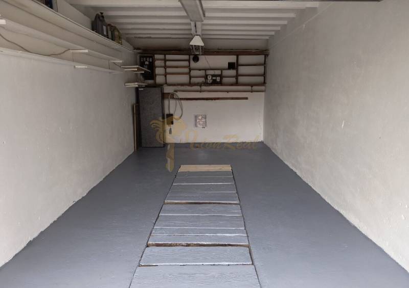 Garáž Púpavova, Karlova Ves + pivnica - Garáž s bielymi stenami a výraznou podlahou na ulici Púpavová, ideálne pre skladovanie.