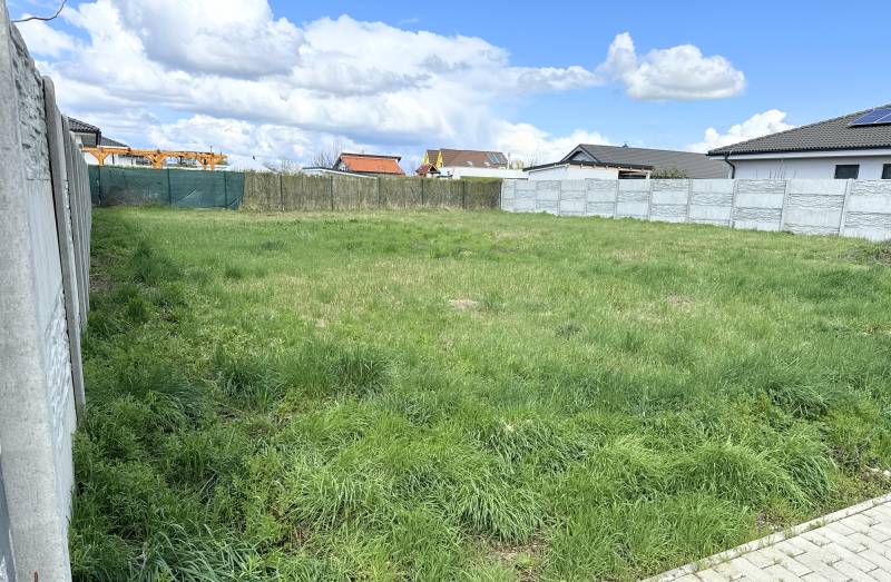 Na predaj stavebný pozemok s IS, Kvetoslavov 643 m² - Pozemok na Bazovej ulici v Kvetoslavove, ideálny na bývanie, obklopený plotom.