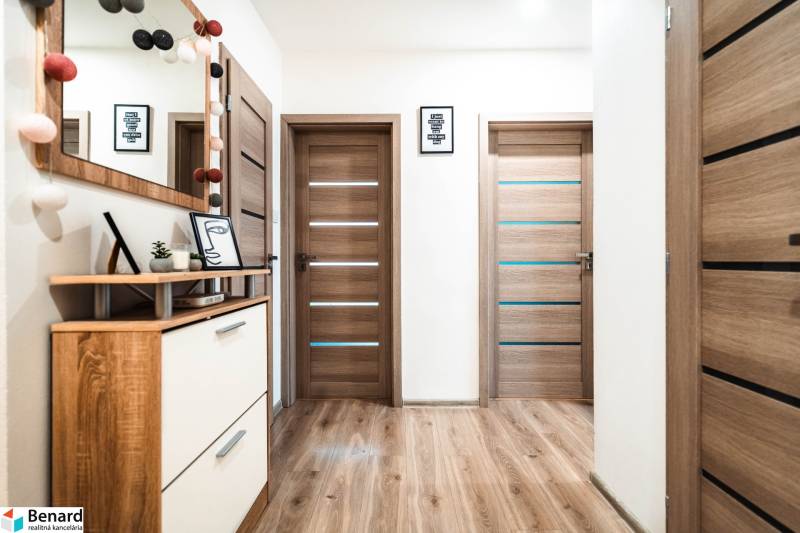 Útulný 2-izbový byt na prenájom - Interiér 2-izbového bytu s podlahou s dreveným dekorom, dverami a dekoráciami.