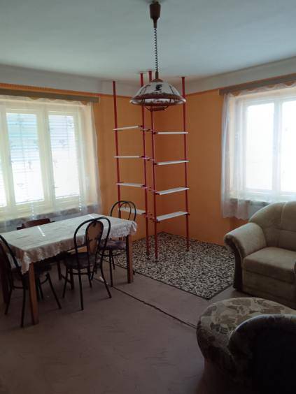 Na predaj rodinný dom Kosihovce - Obývacia izba v rodinnom dome s jedálenským stolom a policovým rebríkom.