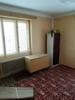 Na predaj rodinný dom Kosihovce - Interiér rodinného domu so skrinkou, stolom a červeným kobercom.