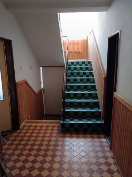 Na predaj rodinný dom Kosihovce - Schodisko s kachličkovou podlahou v rodinnom dome, obložené drevom na stenách.