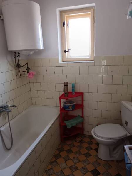 Na predaj rodinný dom Kosihovce - Kúpeľňa rodinného domu s vaňou, kachličkami a oknom.