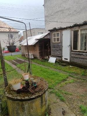 Na predaj rodinný dom Kosihovce - Záhrada pri rodinnom dome v Kosihovciach s trávnikom a staršou prístavbou.