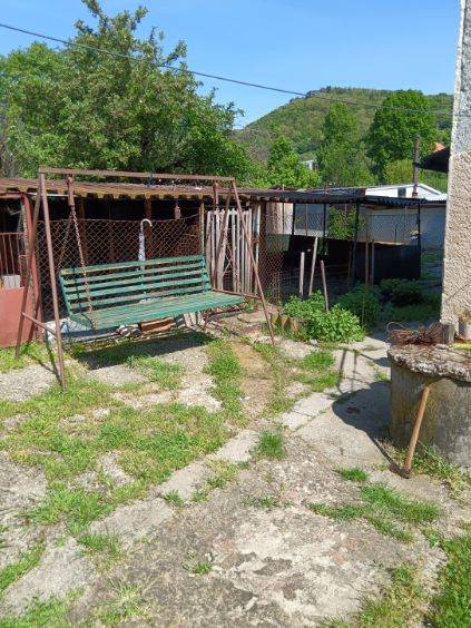 Na predaj rodinný dom Kosihovce - Záhrada rodinného domu v Kosihovciach so starou hojdačkou a altánkom, trávnik a chodník.