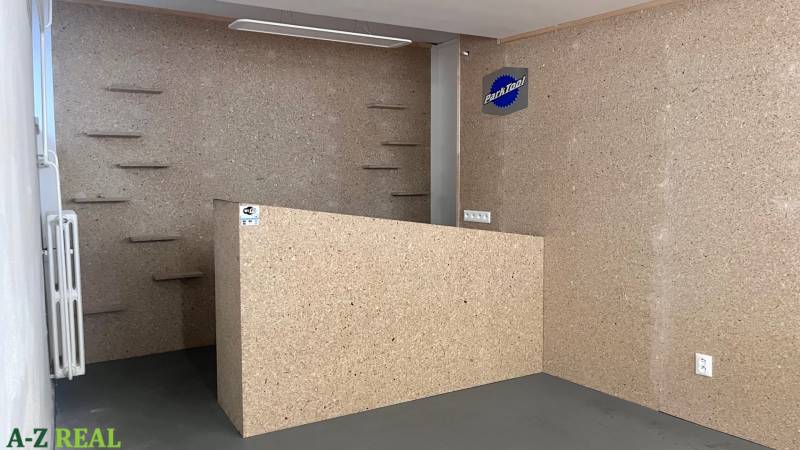 Prenájom obchodno-kancelárskeho priestoru na Račianskej ul.,141 m2 - Interiér obchodných priestorov s dreveným dekorom a policami na stene.