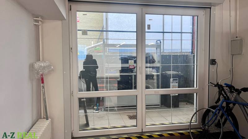 Prenájom obchodno-kancelárskeho priestoru na Račianskej ul.,141 m2 - Sklenené posuvné dvere v obchodných priestoroch, bicykel, radiátor a plastová fólia na stene.